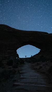 person standing near mountain during nighttime wallpaper