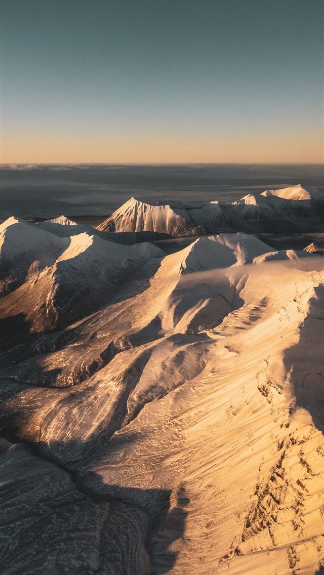 brown and white mountains under blue sky during da... iPhone wallpaper 