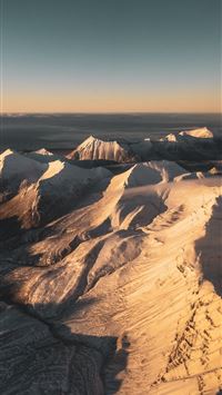 brown and white mountains under blue sky during da... wallpaper