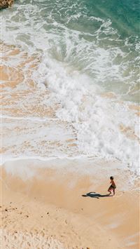 woman walking on seashore wallpaper