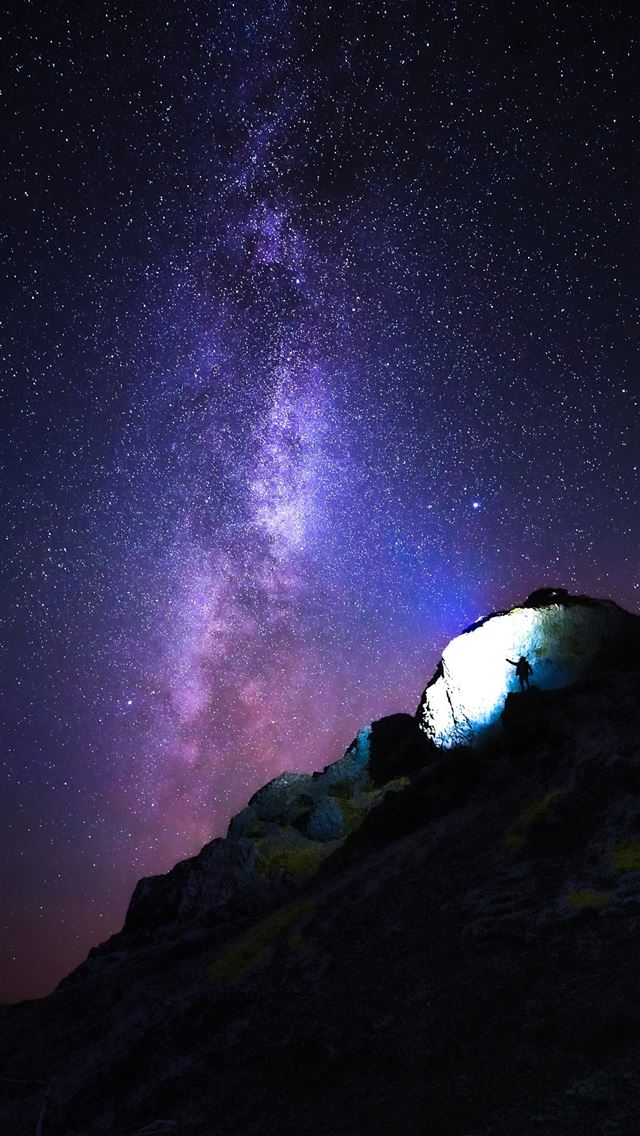 person standing on rock mountain under starry nigh... iPhone wallpaper 