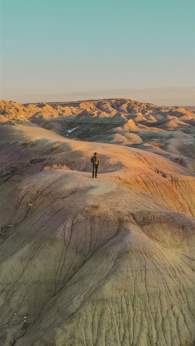640x1136 person standing on brown rock formation during day... -  iPhone Wallpaper