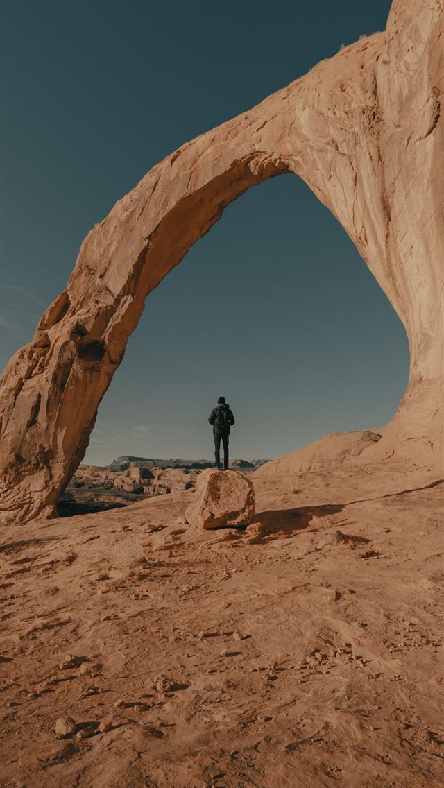640x1136 man in black jacket standing on brown rock formati... - ut iPhone Wallpaper