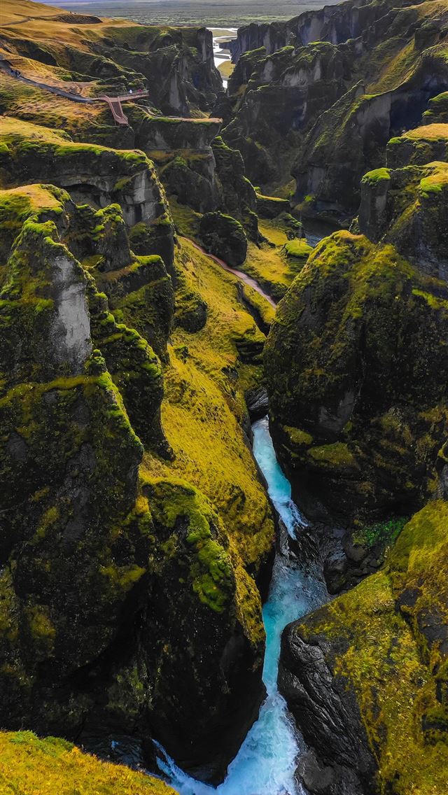 river in the middle of green and yellow mountains iPhone wallpaper 