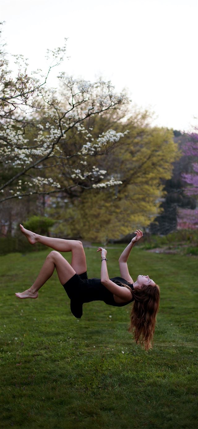 1125x2436 woman back flipping in the garden -  iPhone X Wallpaper