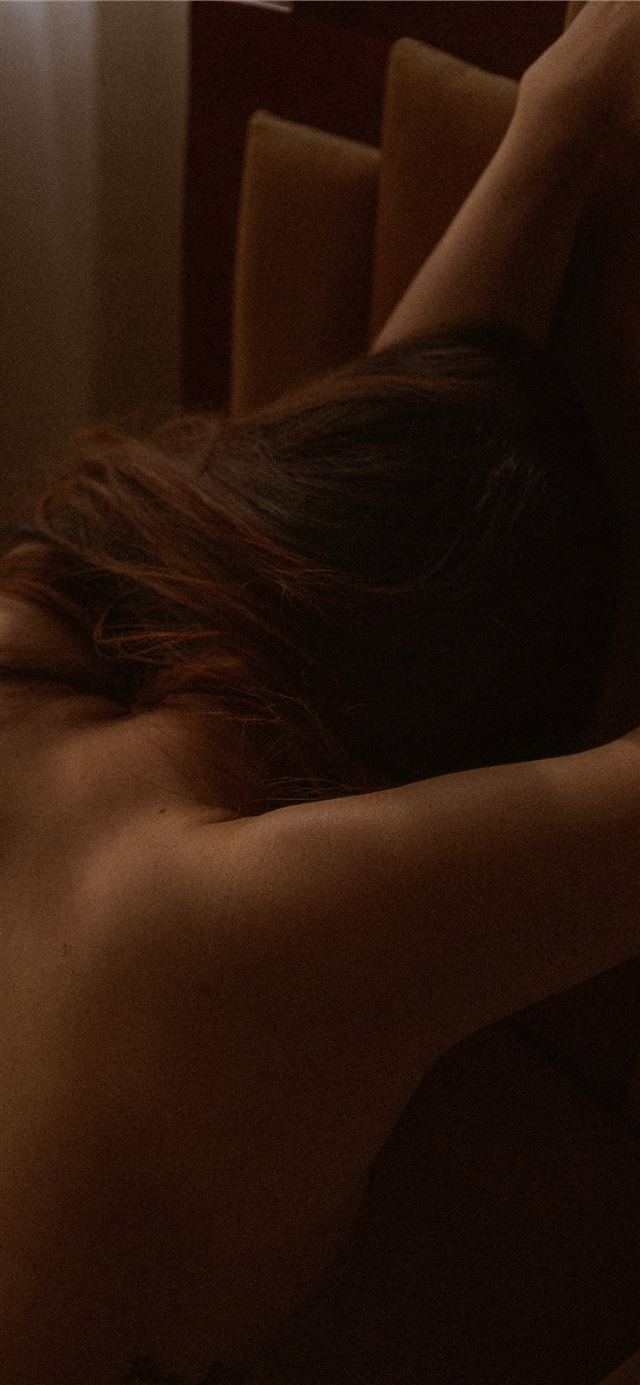 1125x2436 topless woman leaning forward on brown surface -  iPhone X Wallpaper