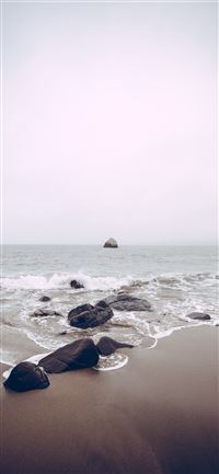 rocks on sea side at daytime wallpaper