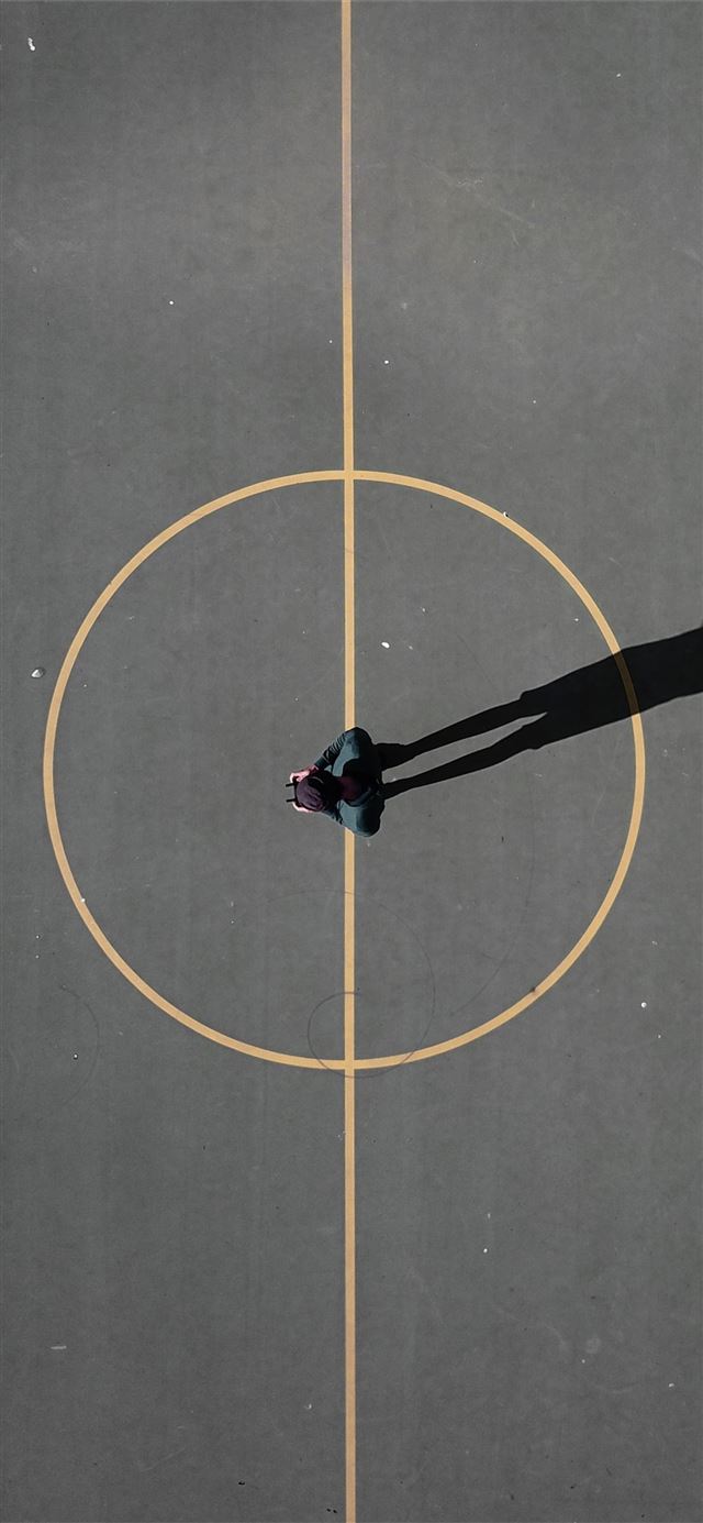 1125x2436 man stainding on black concrete floor casting shad... -  iPhone X Wallpaper