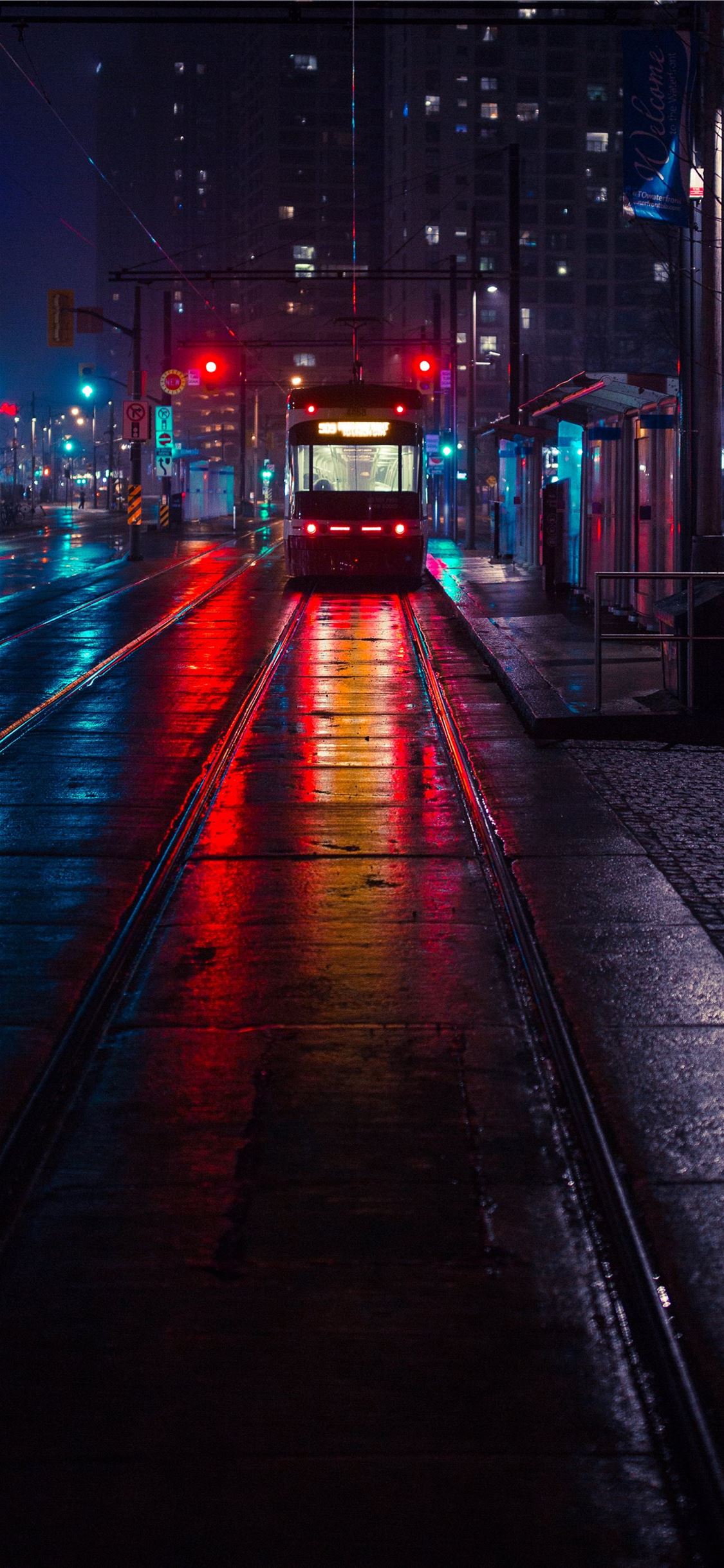 photo of tram beside waiting station during nightt... iPhone X wallpaper 