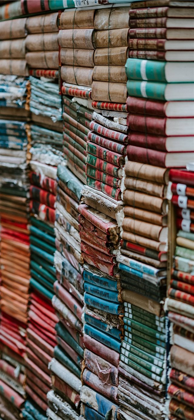 1125x2436 Piles of old worn books - literature iPhone X Wallpaper