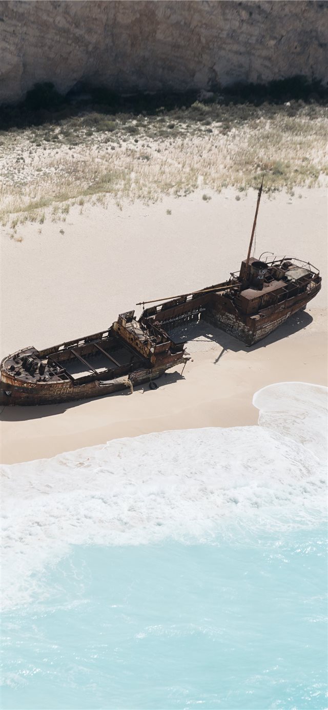 1125x2436 wrecked brown ship on seashore - vehicle iPhone X Wallpaper