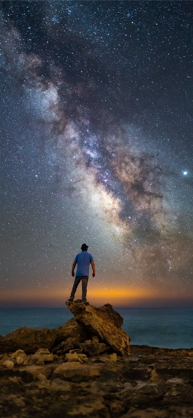 1125x2436 man standing on rock facing ocean under starry nig... -  iPhone X Wallpaper