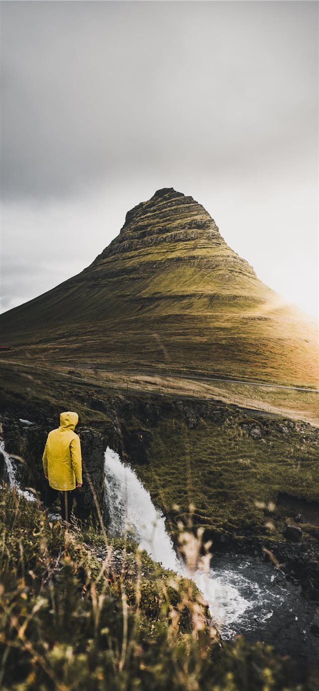 1125x2436 person standing on cliff near waterfalls during da... - yellow iPhone X Wallpaper