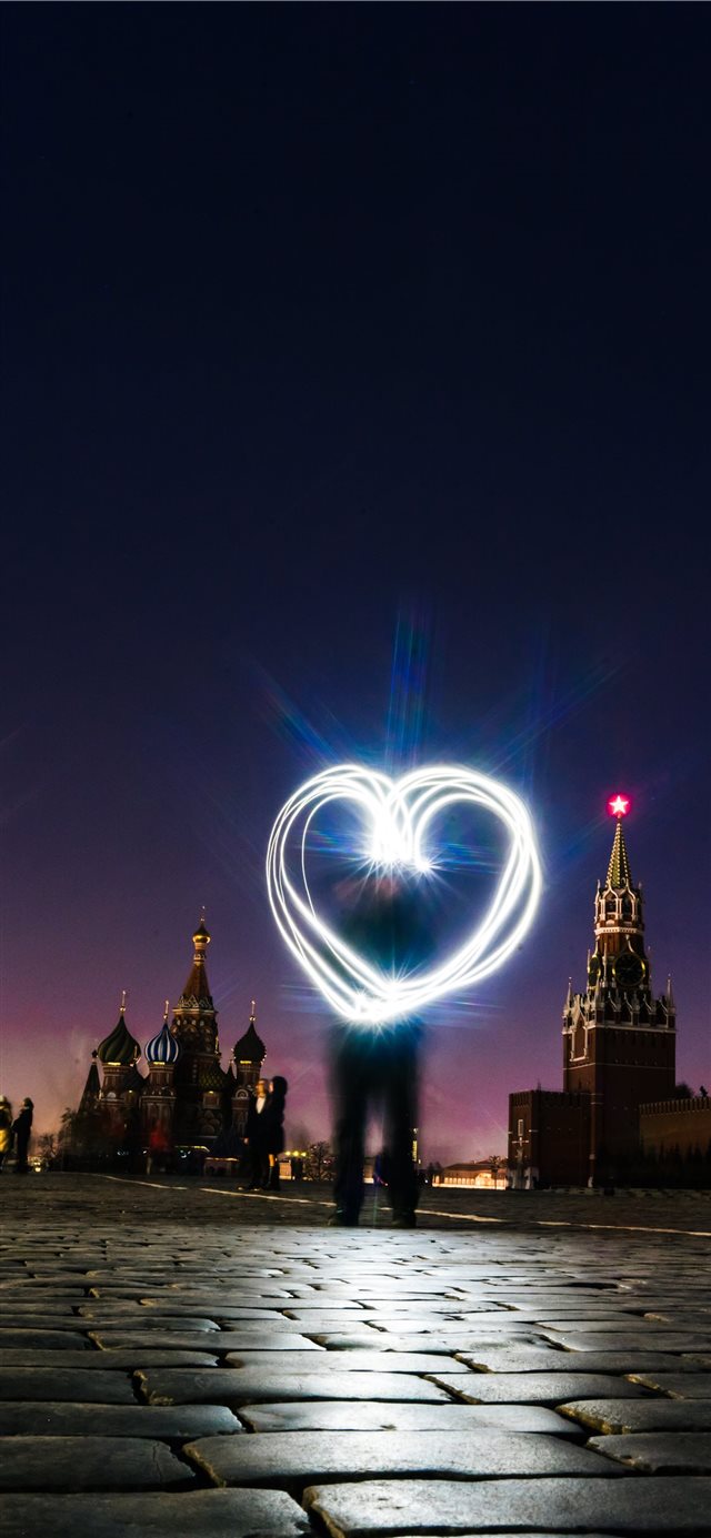 1125x2436 man forrming heart light - moscow iPhone X Wallpaper