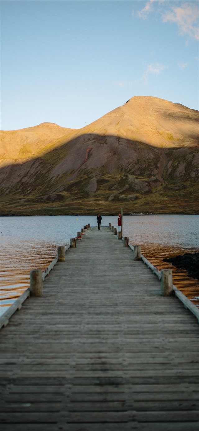 1125x2436 person standing at edge of dock - water iPhone X Wallpaper