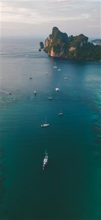 white boats on ocean water under gray sky wallpaper