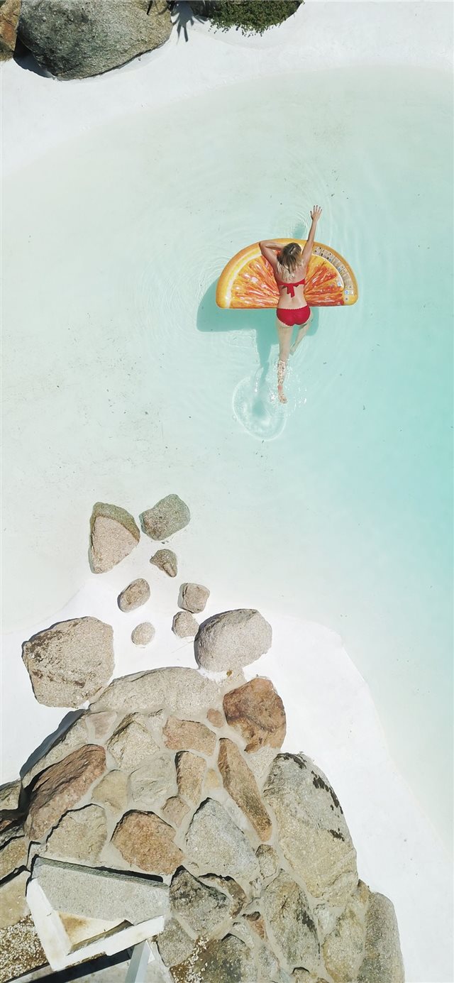 1125x2436 woman on swim ring - water iPhone X Wallpaper