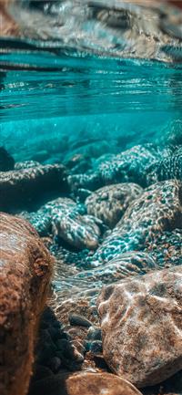 underwater photography of brown stones wallpaper