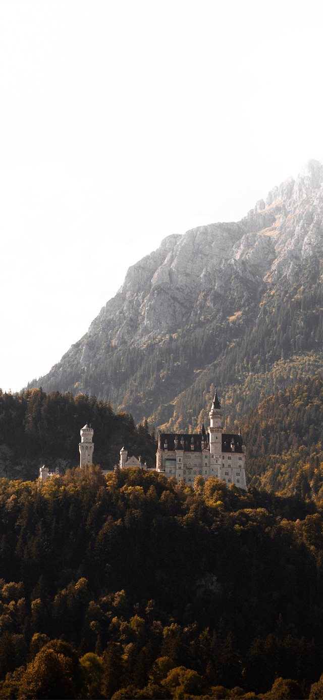 1125x2436 white and brown concrete building beside mountain ... - germany iPhone X Wallpaper