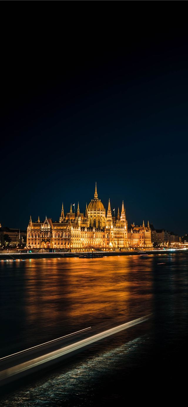 1125x2436 brown concrete building near body of water during ... - city iPhone X Wallpaper