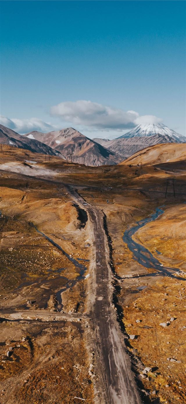 1125x2436 brown and gray mountains under blue sky during day... - scenery iPhone X Wallpaper