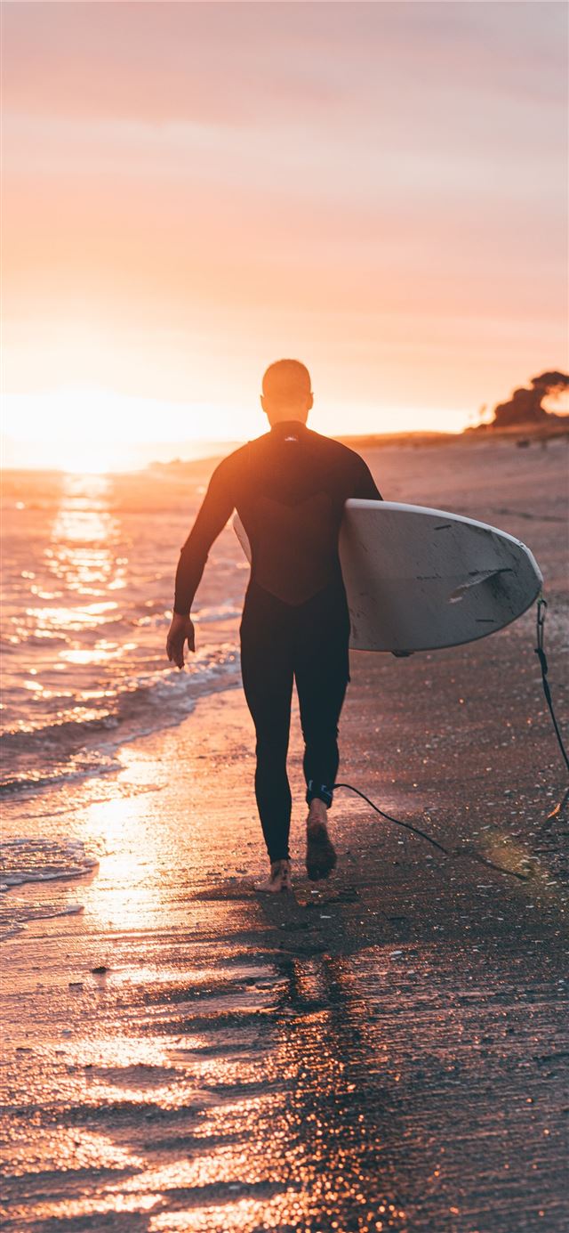 1125x2436 man holding white surfboard - new zealand iPhone X Wallpaper