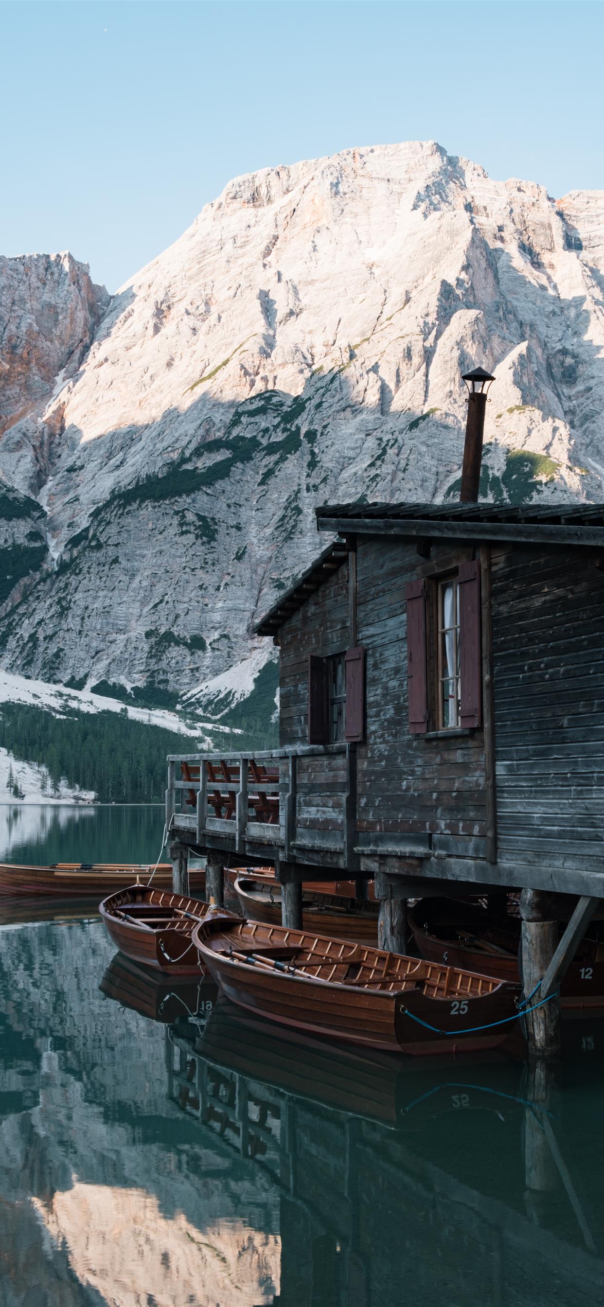 A house in the lake with a few boats iPhone X Wallpapers Free Download