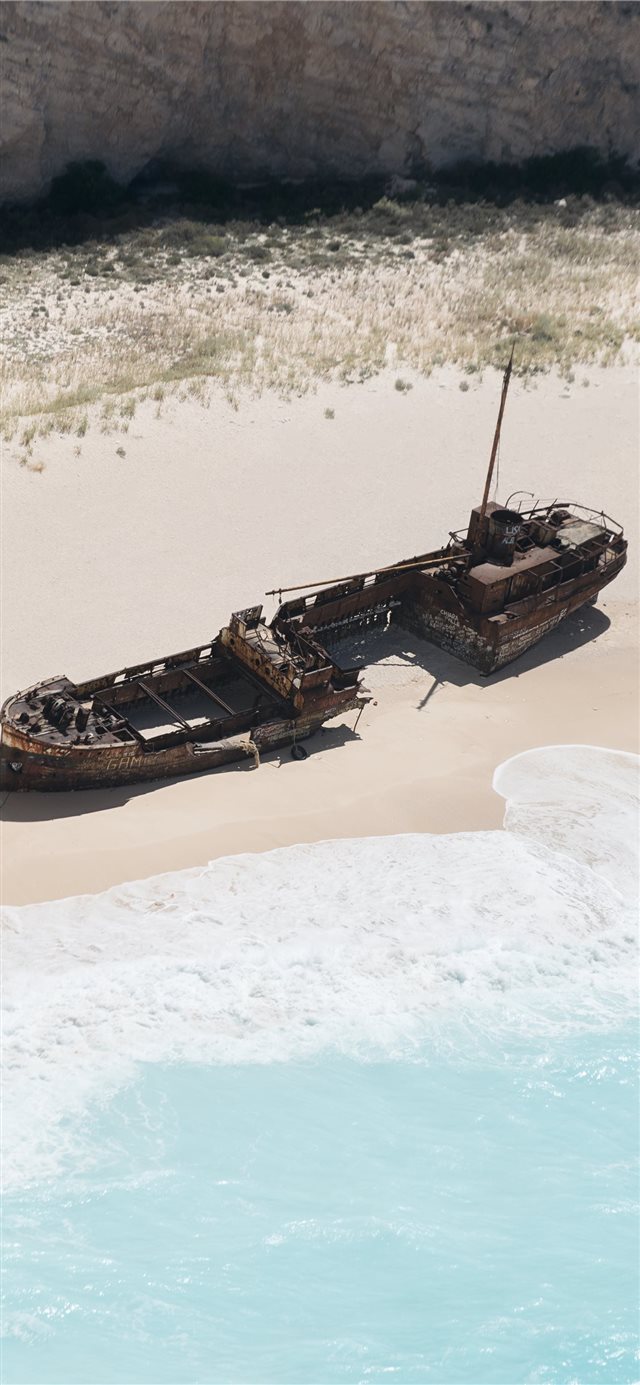 wrecked brown ship on seashore iPhone X wallpaper 