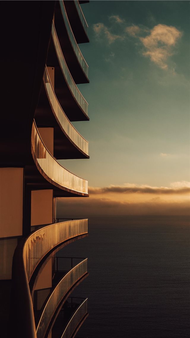 gray painted building and sea ocean iPhone 8 wallpaper 