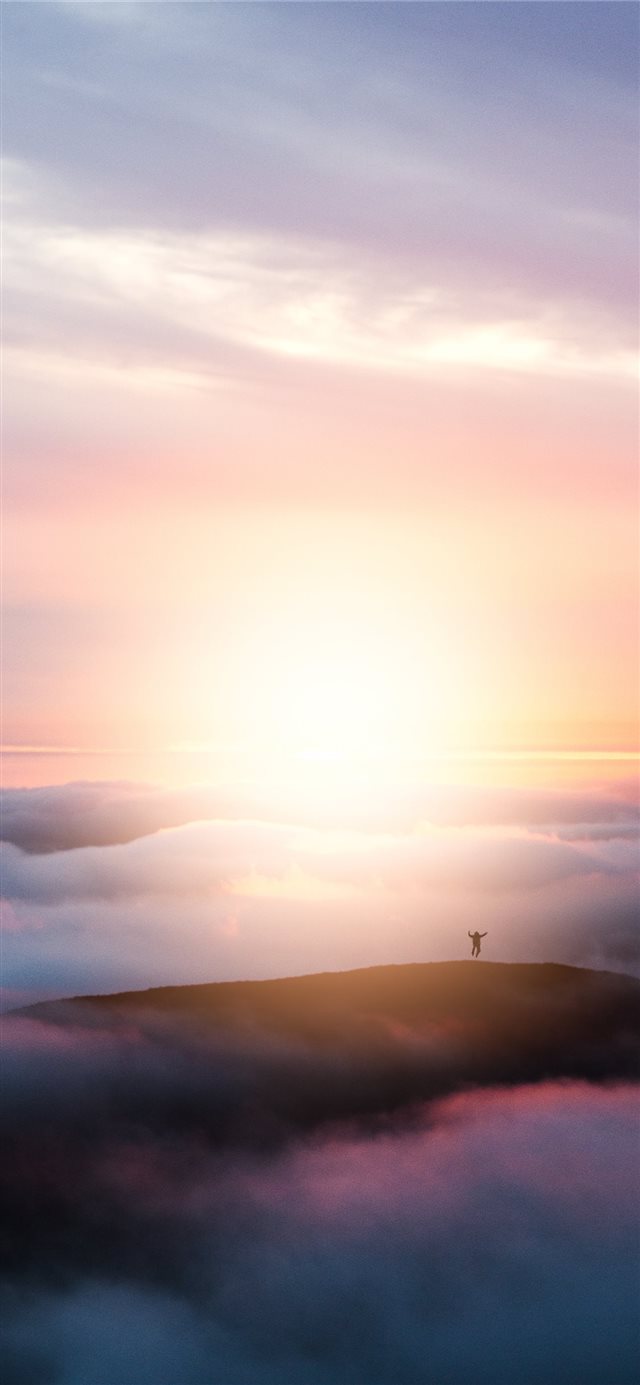 man jumping on hill during golden hour iPhone 11 wallpaper 