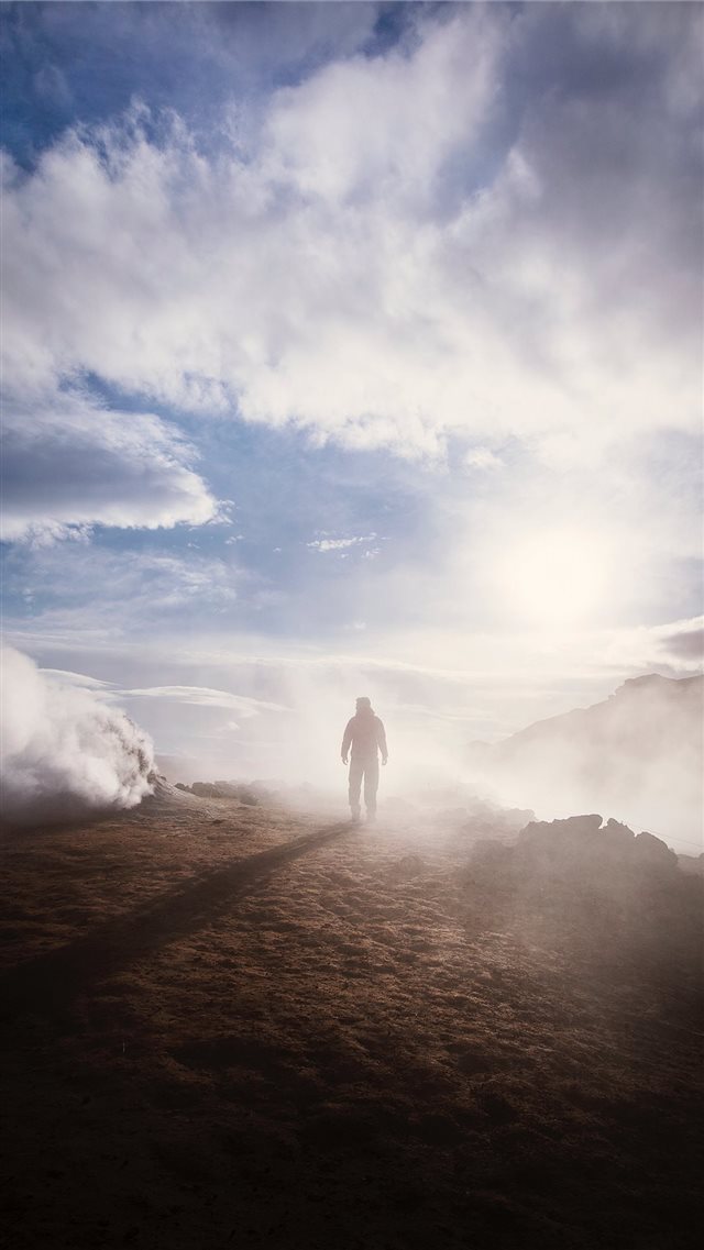 person standing near the edge of a mountain near c... iPhone 8 wallpaper 