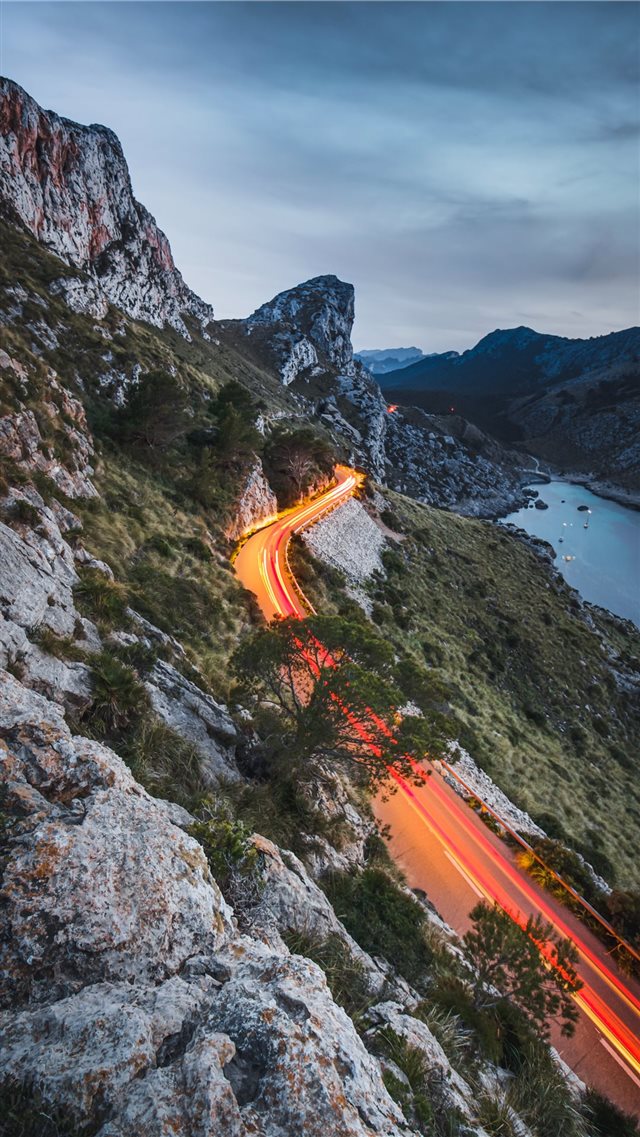 road beside a cliff near body of water during dayt... iPhone 8 wallpaper 