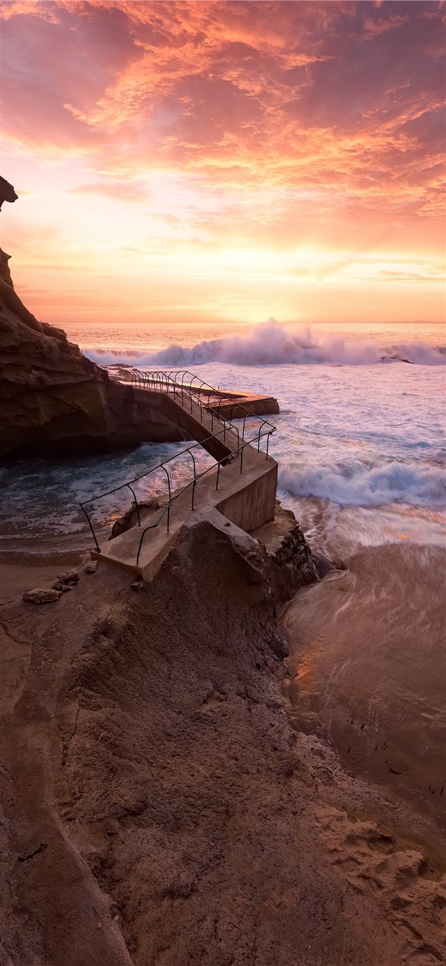 waves crashing on rocky coast during sunset iPhone X wallpaper 