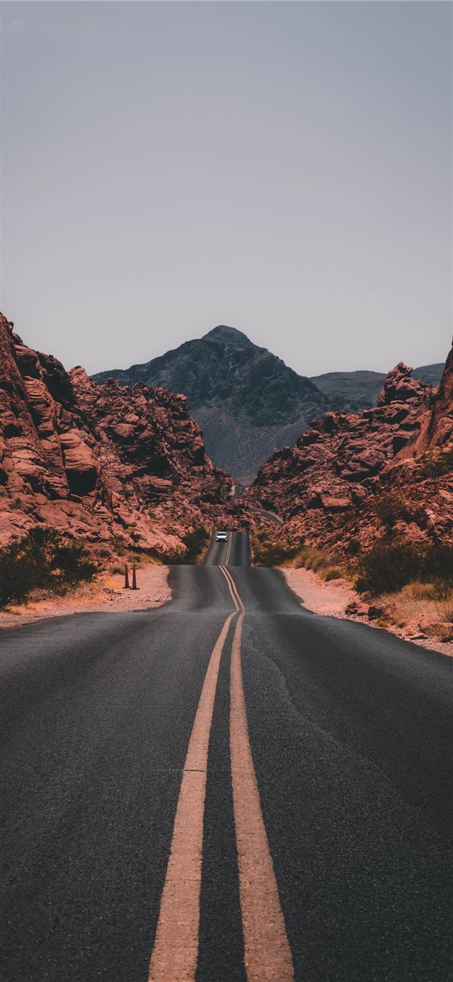 black concrete road surrounded by brown rocks iPhone 11 wallpaper 
