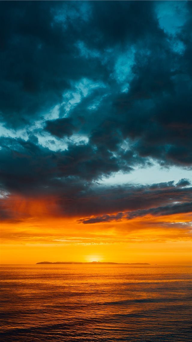 green and black clouds partly covering orange sky ... iPhone 8 wallpaper 