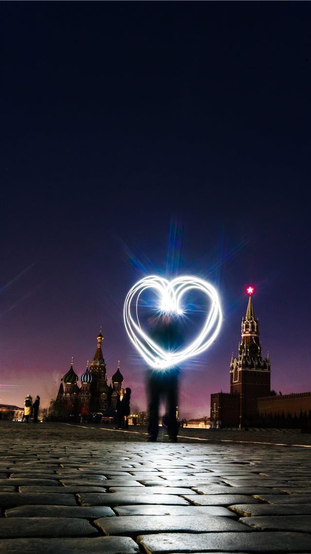 man forrming heart light iPhone 8 wallpaper 