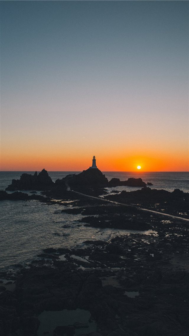 man standing on rock formation during golden hour iPhone 8 wallpaper 
