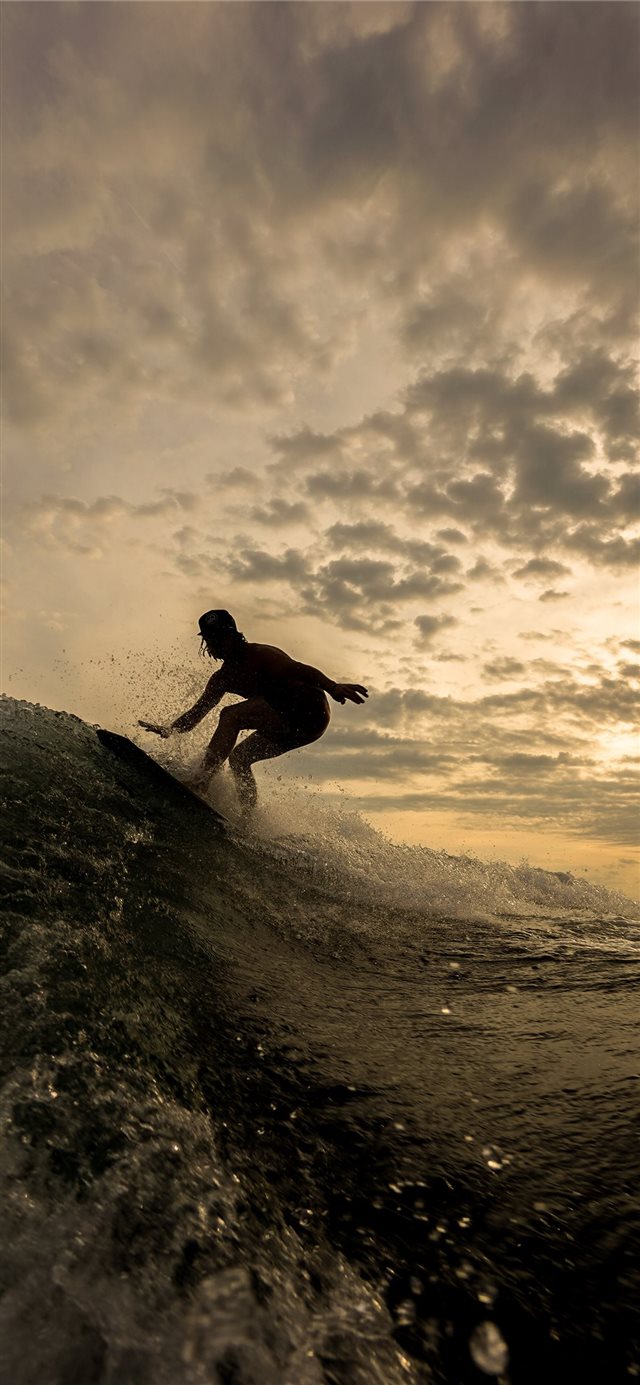silhouette of person riding on surfboard iPhone 11 wallpaper 