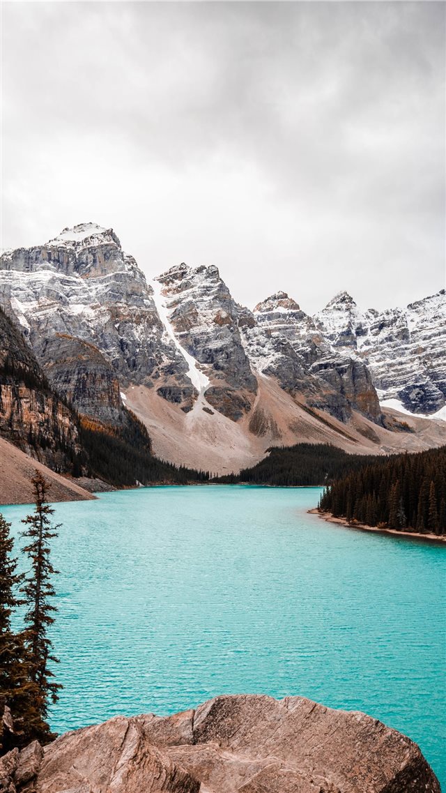 body of water near trees and glacier mountains dur... iPhone 8 wallpaper 