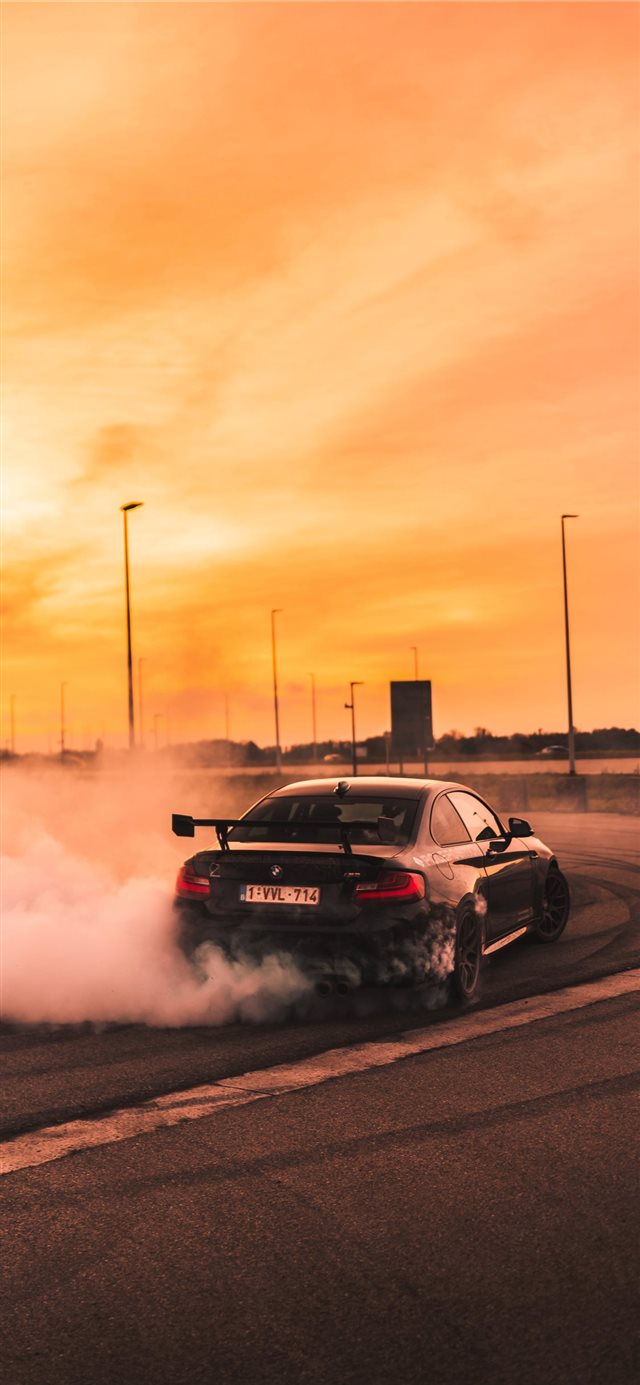 black car drifting on road during day iPhone X wallpaper 