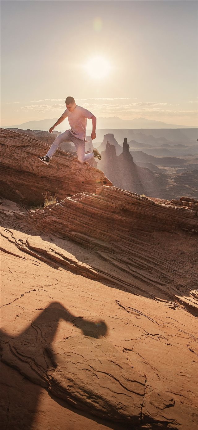 man jumping under sunlight iPhone 11 wallpaper 