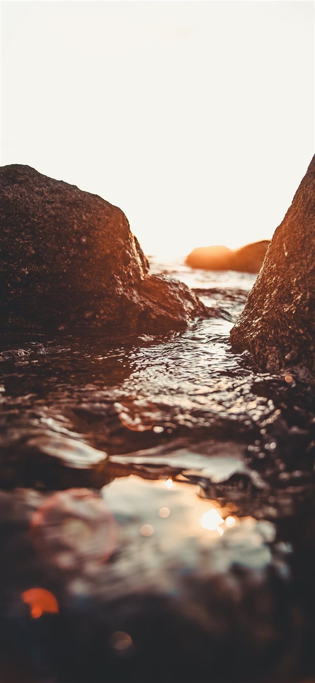 rocky seashore during golden hour iPhone X wallpaper 
