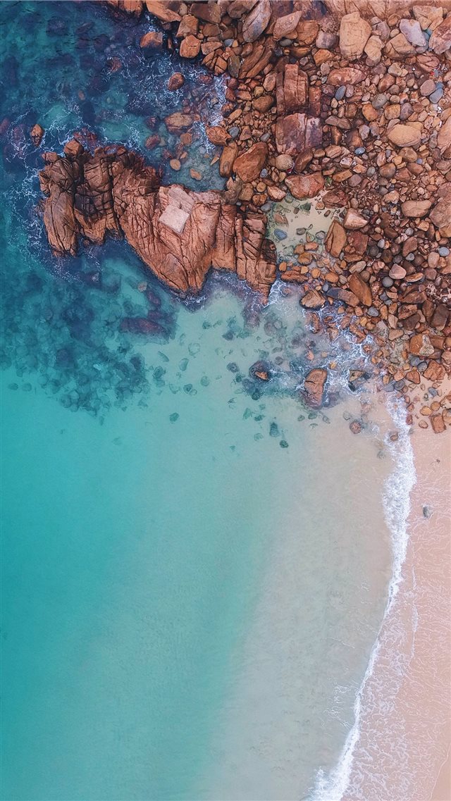 aerial view of rocks near body of water iPhone 8 wallpaper 