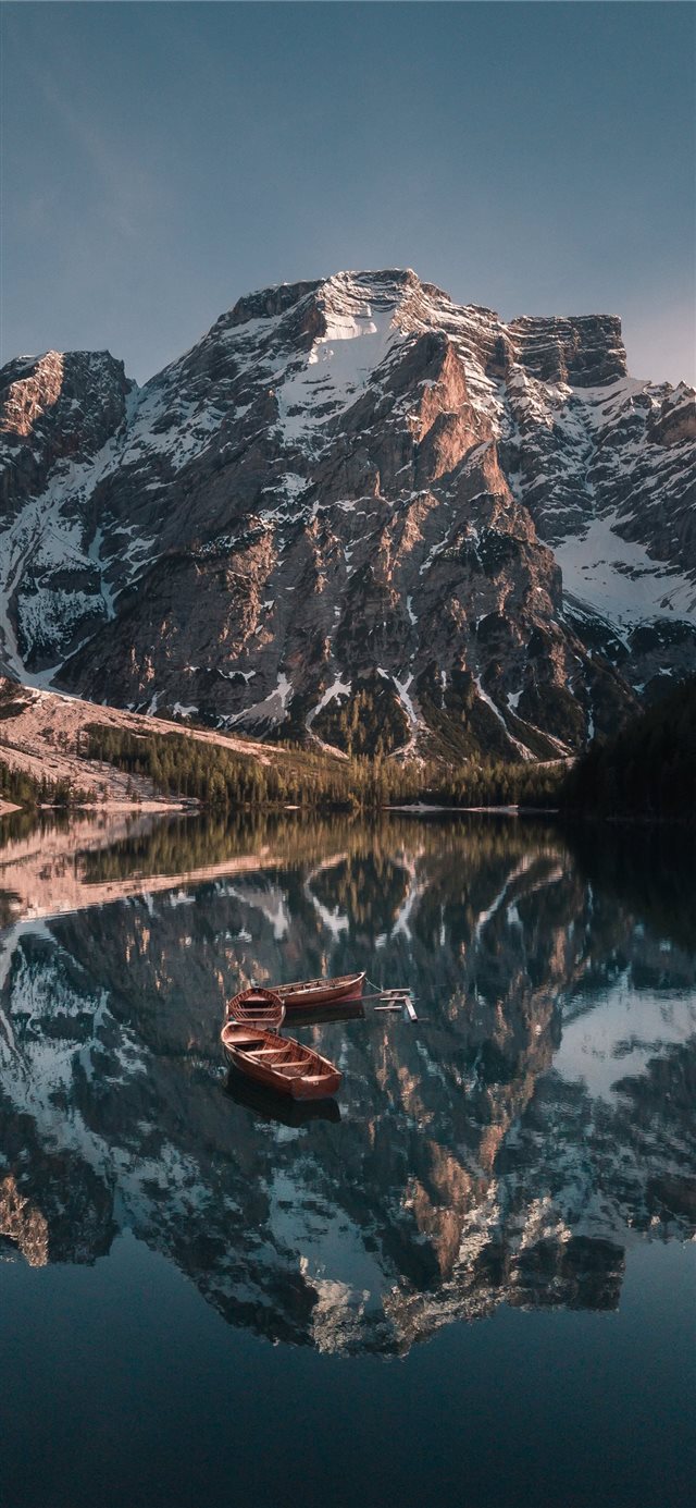 empty boats on body of water near glacier mountain... iPhone X wallpaper 