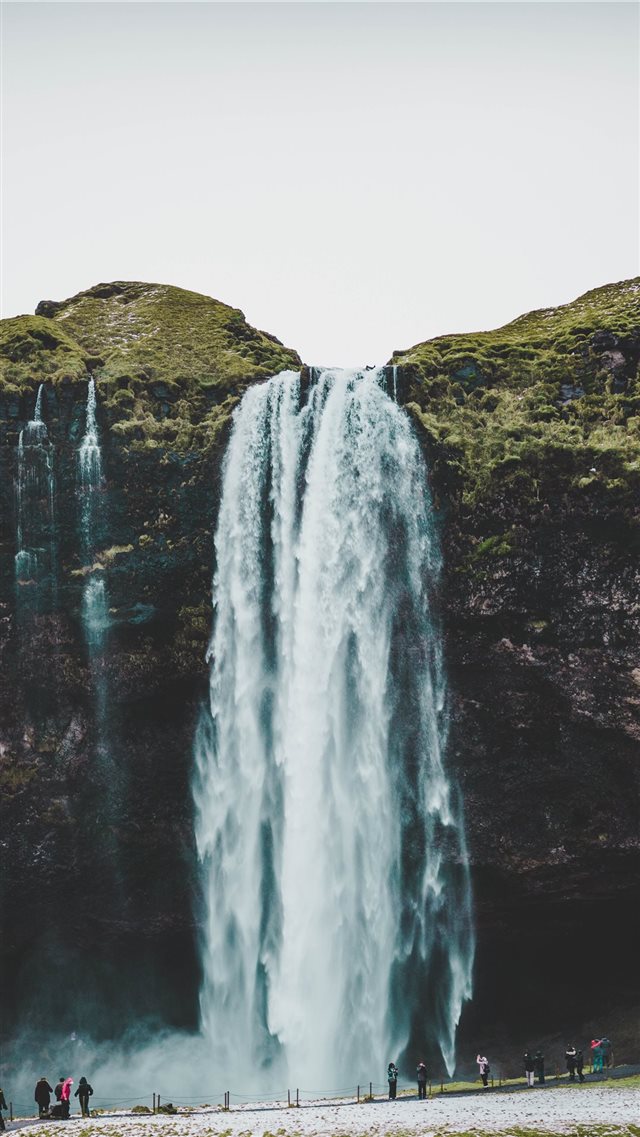group of people standing near waterfalls iPhone 8 wallpaper 