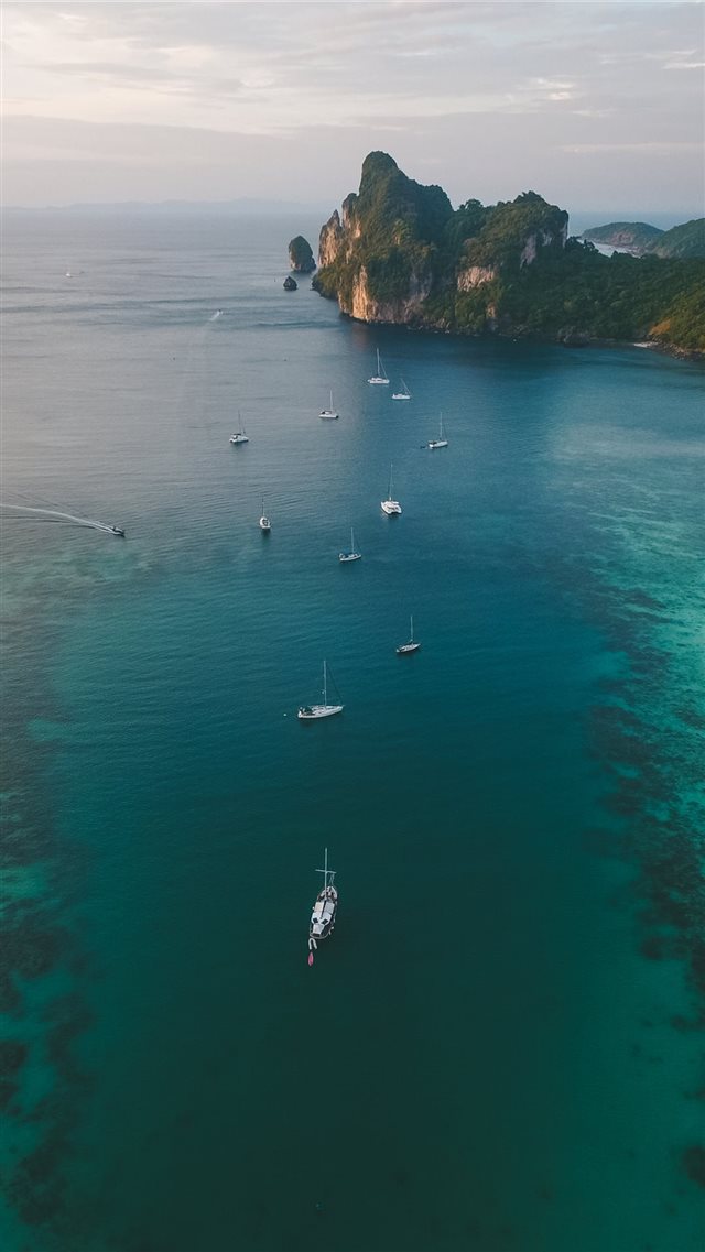 white boats on ocean water under gray sky iPhone 8 wallpaper 