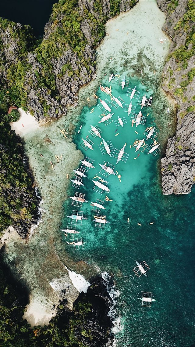 aerial photography of boats beside mountain during... iPhone 8 wallpaper 