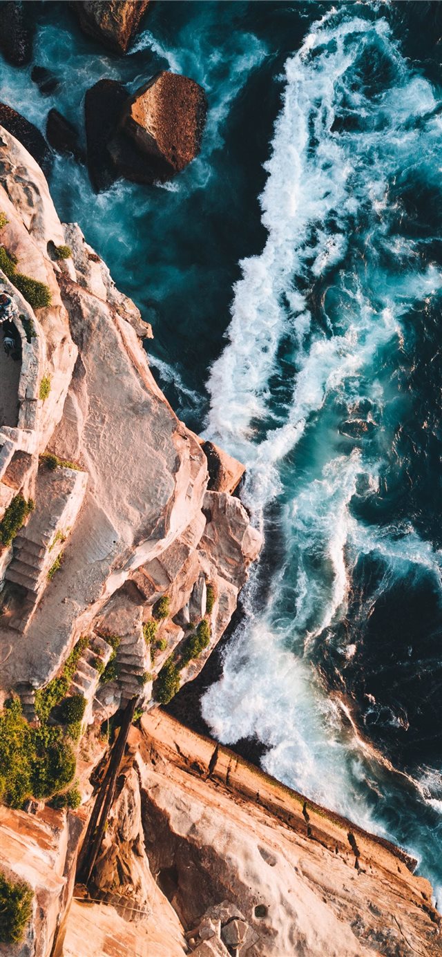 aerial photography of rocky mountain and beach iPhone X wallpaper 