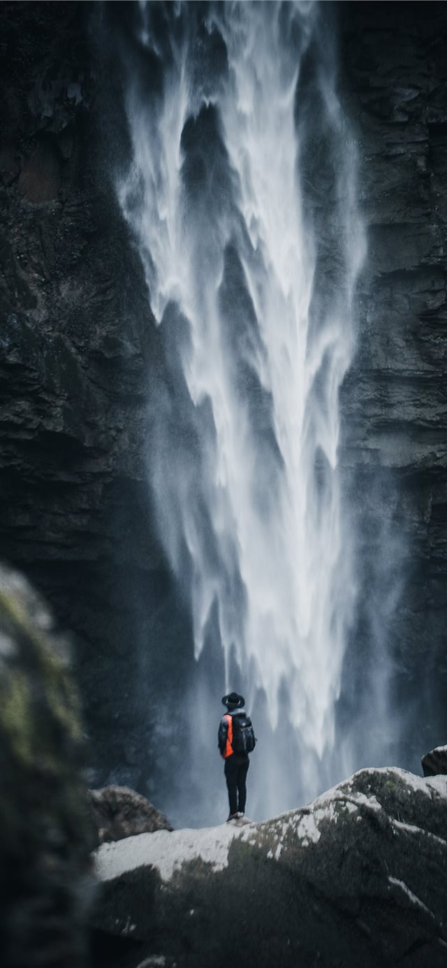 man standing near waterfalls iPhone 11 wallpaper 