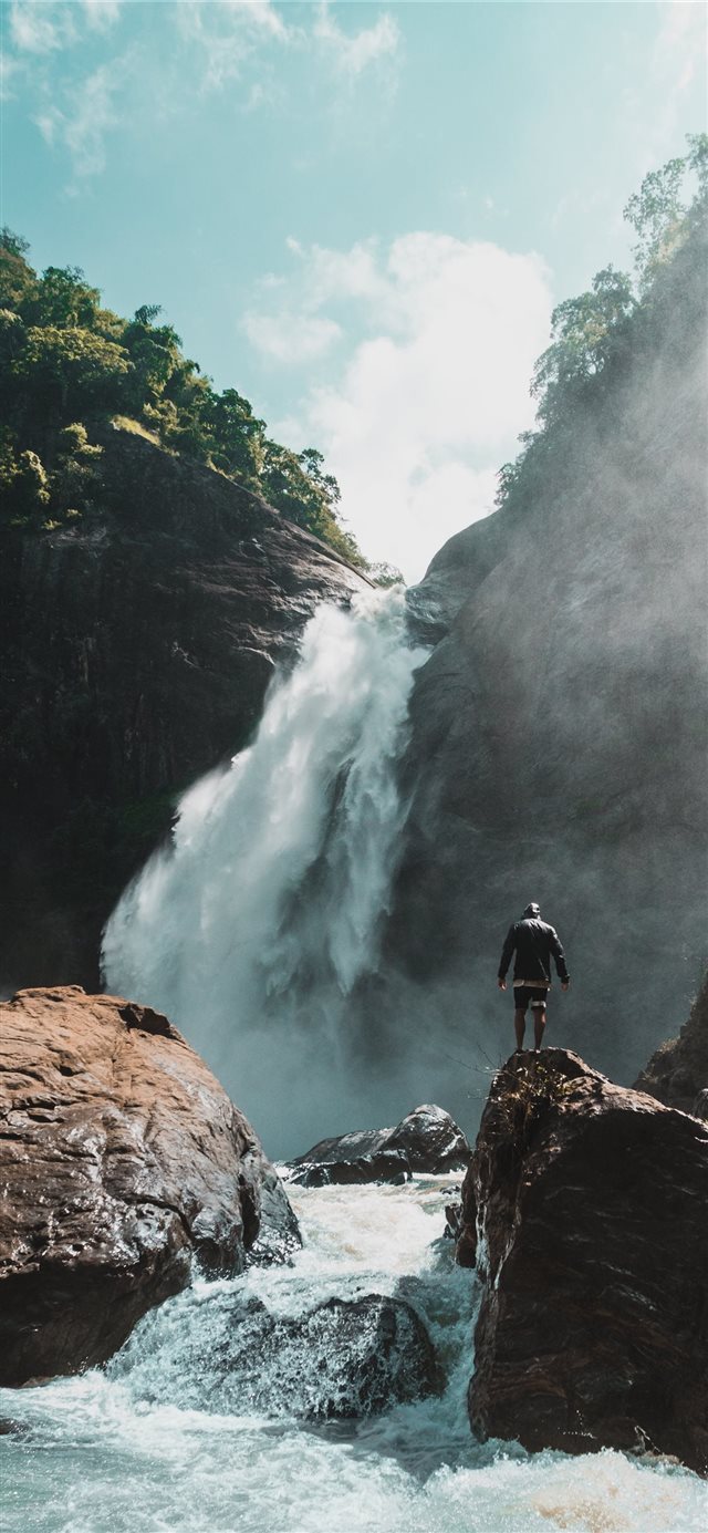 man standing stone with waterfalls iPhone X wallpaper 
